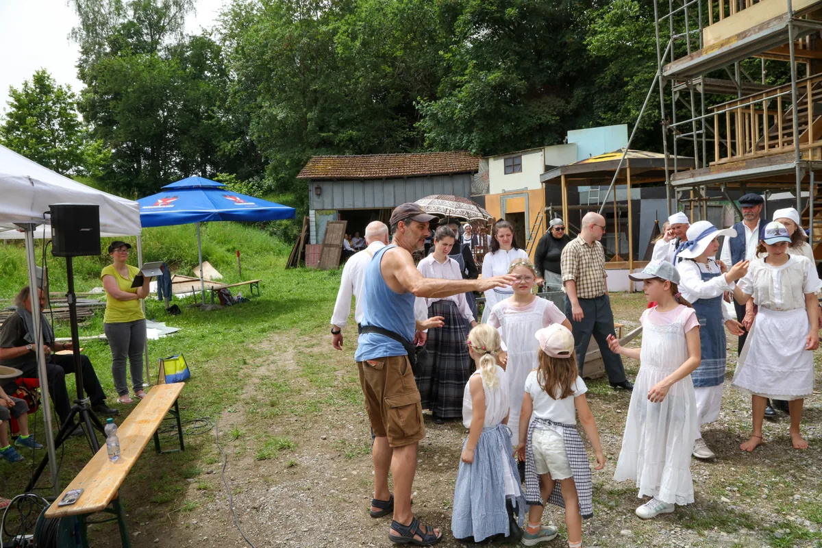 Regisseur René Schnoz (im blauen Leibchen) weiss genau, was er von seinen rund 60 Darstellenden sehen will. Man sieht eine Gruppe von Menschen in historischen Kostümen.